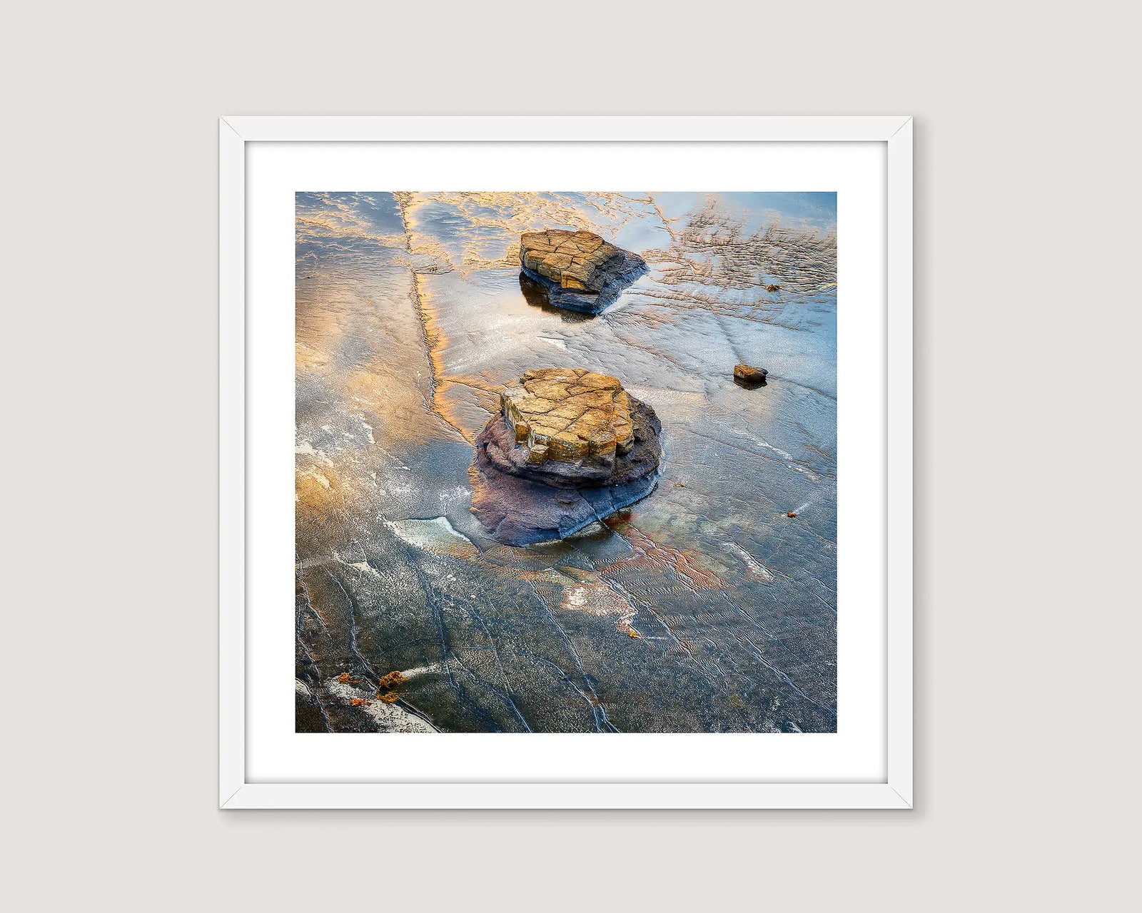 Framed abstract photograph of rocks on a beach with a white border