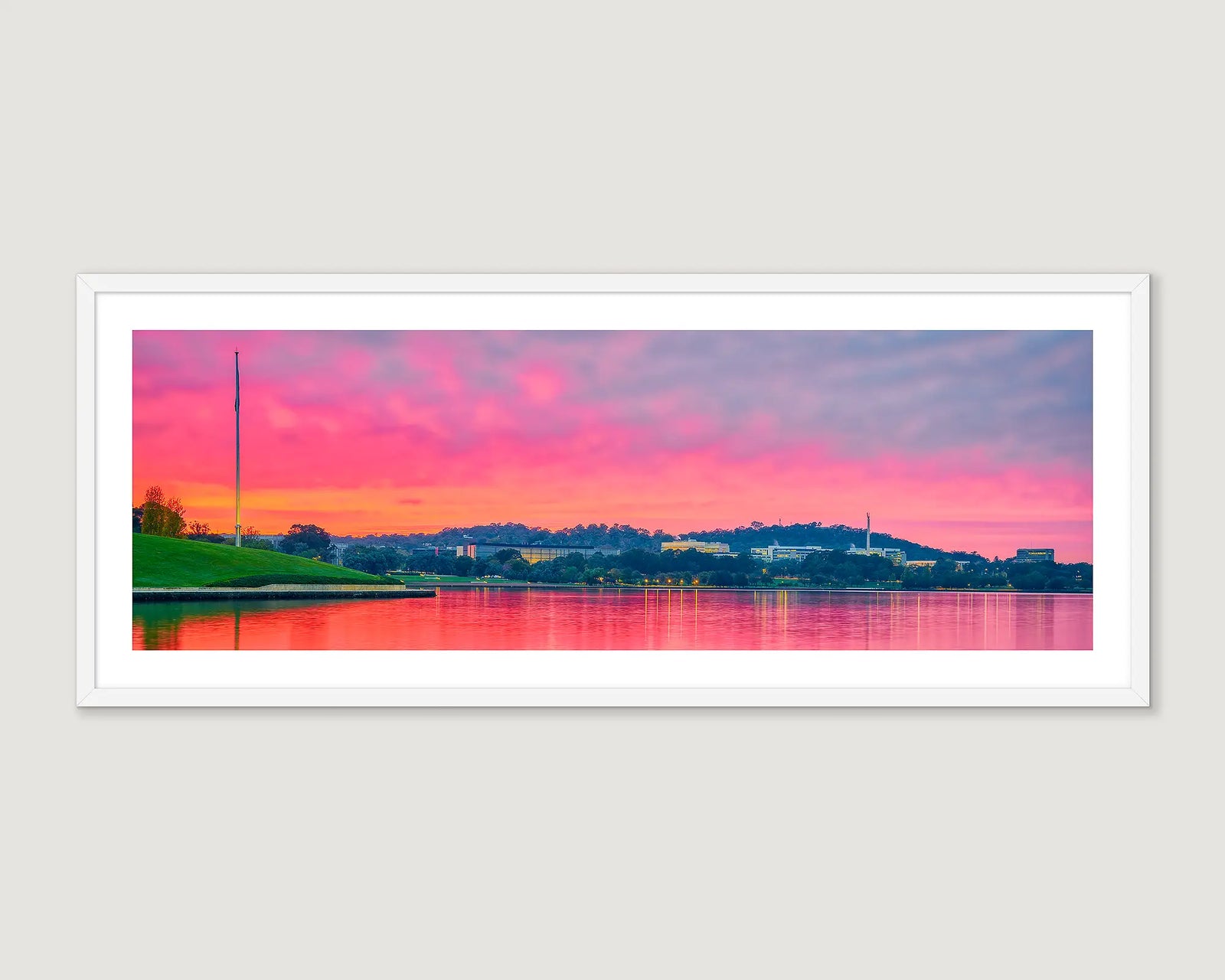 Framed photograph of a colourful sunrise with Lake Burley Griffin and Russell Offices and hills.