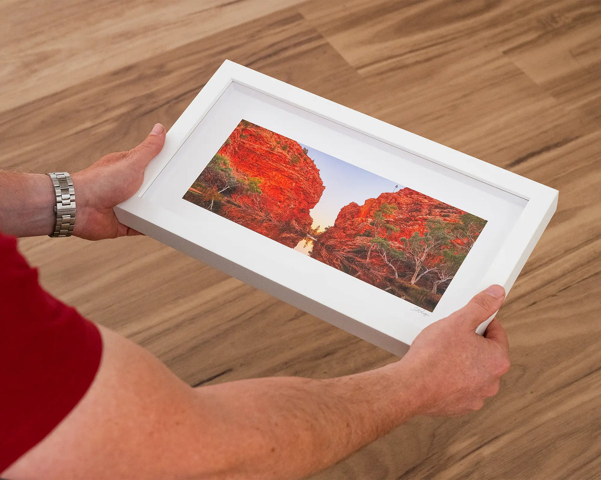 Sacred Waterhole. Ellery Creek Big Hole, Northern Territory, small print with white frame, held in hands.