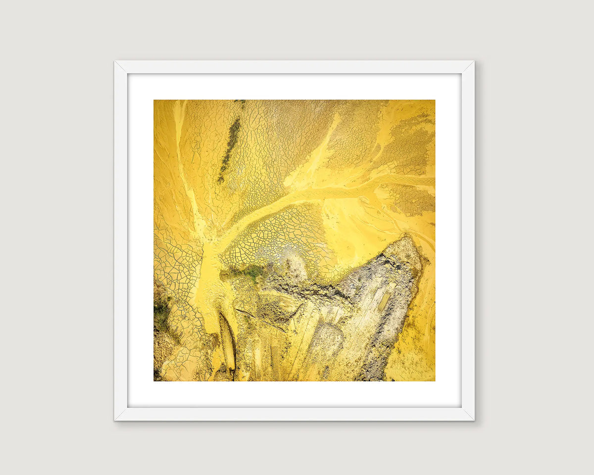 Framed artwork of a yellow and grey abstract design.