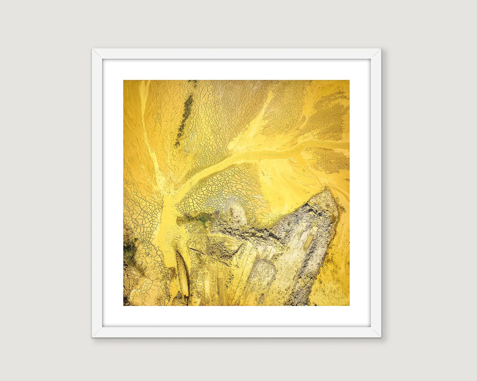 Framed artwork of a yellow and grey abstract design.