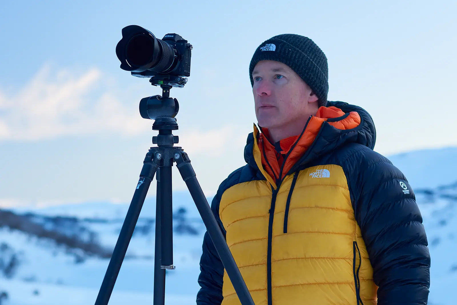 Scott Leggo outdoors, taking photographs in the snow.