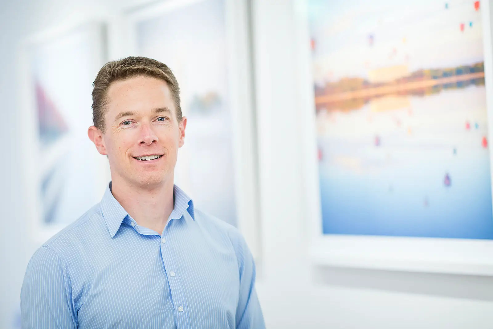 Scott Leggo standing in front of his artworks in his Canberra gallery.