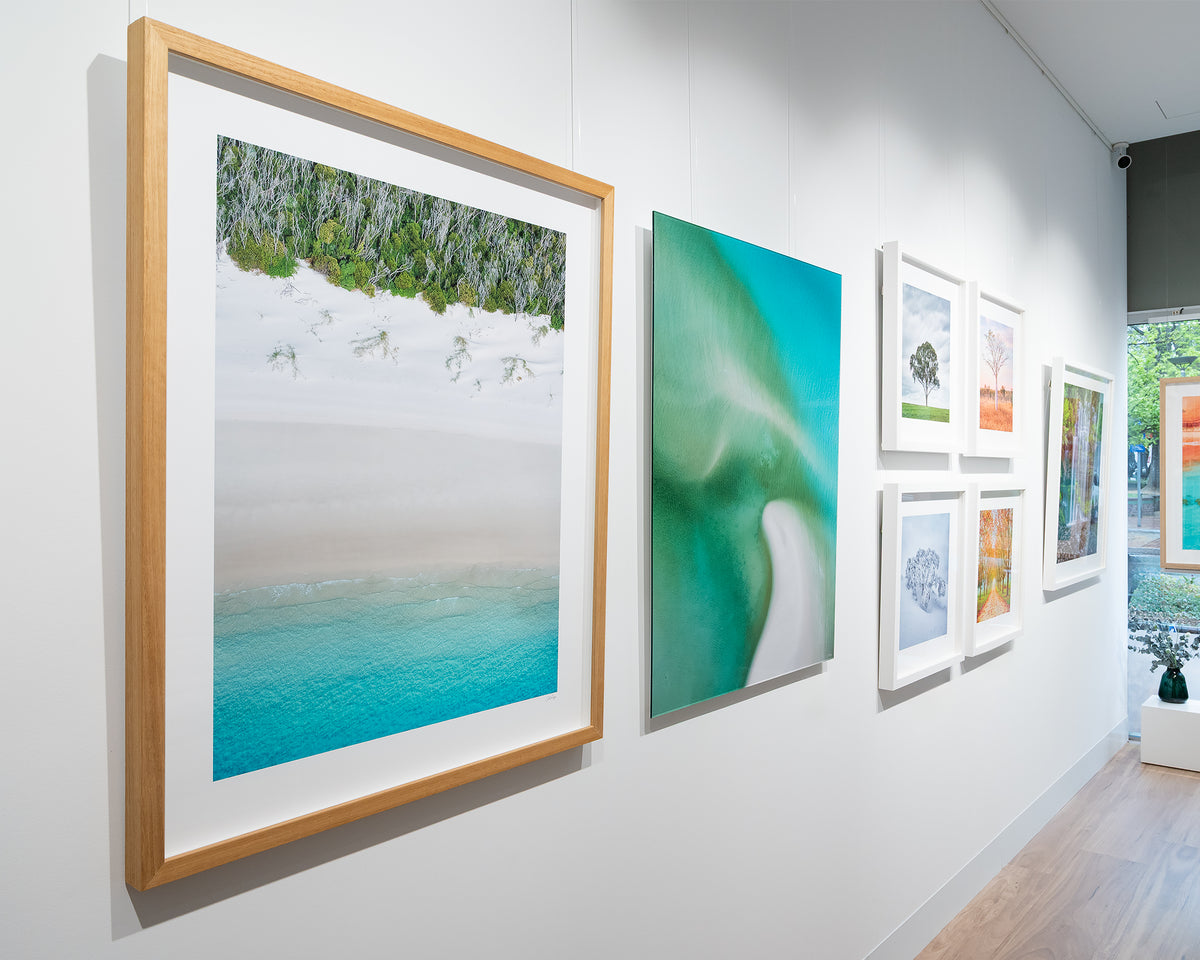 Sea Change. Aerial view Whitehaven Beach, Queensland, with timber frame, displayed in gallery.