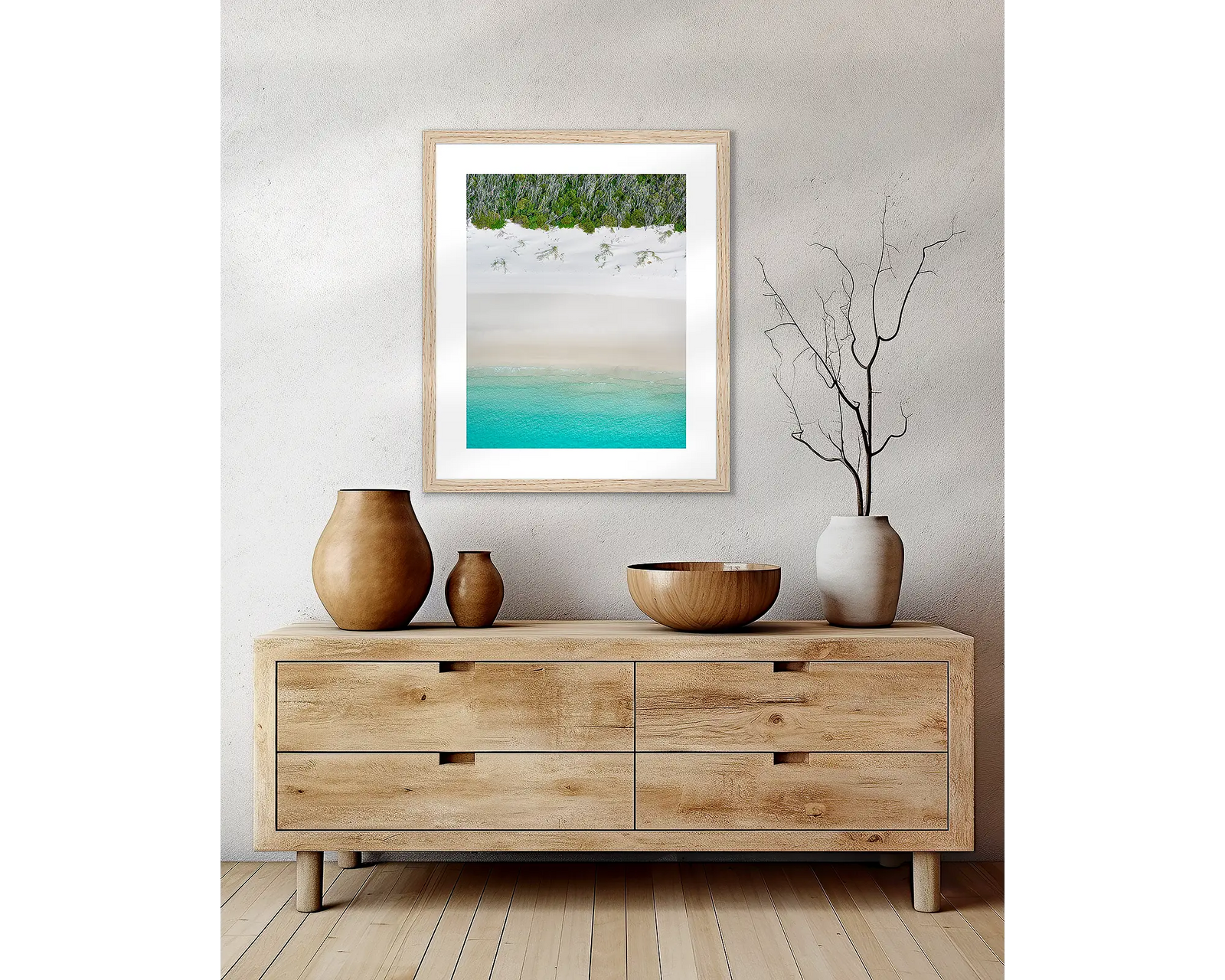 Framed abstract artwork of a beach landscape with turquoise water, white sand and greenery.