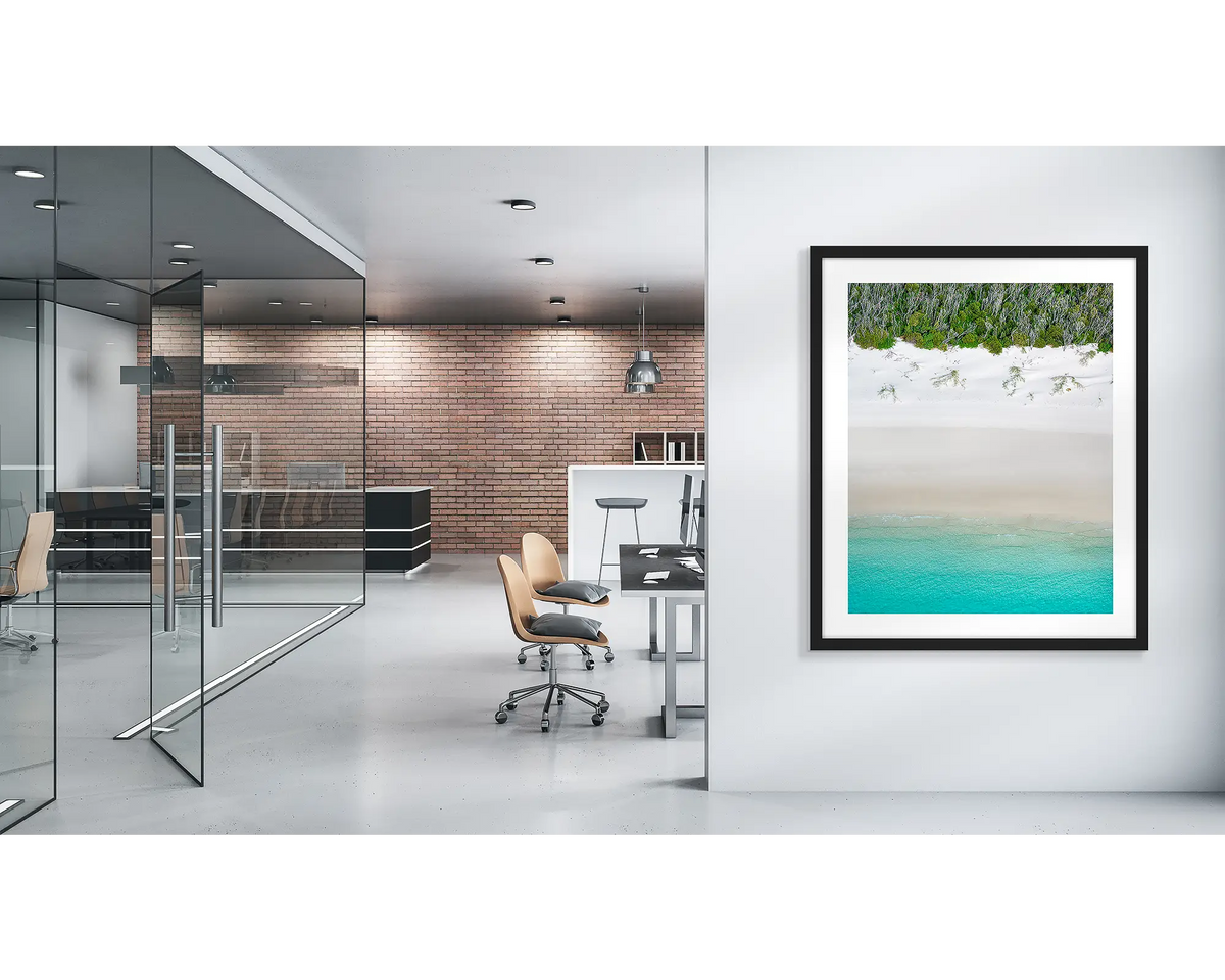 Sea Change. Whitehaven beach wall art print with a black frame, in a modern office. 