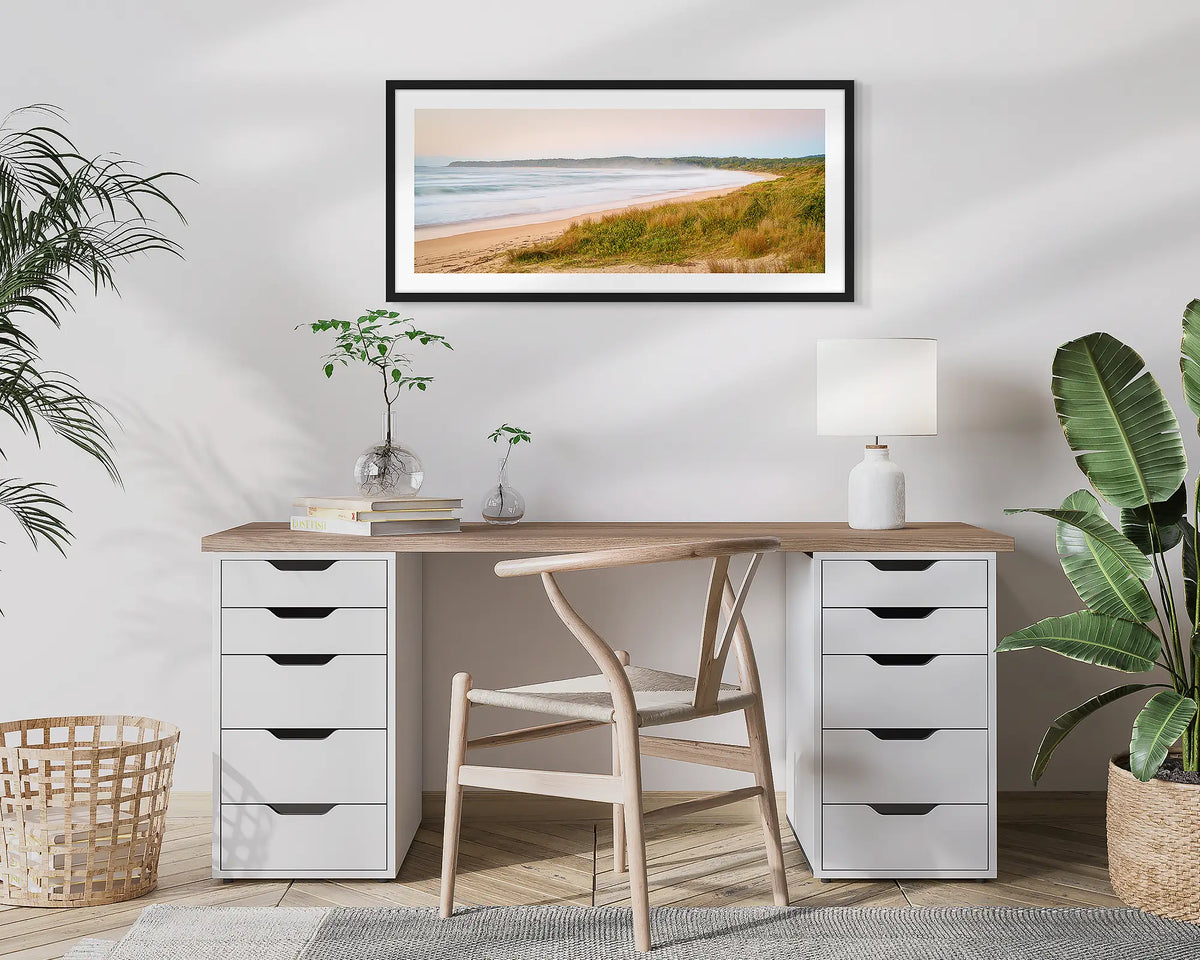 Seaside Dawn. Wall art print of a sunrise at Durras Beach, with a black frame, hung above a home office desk. 