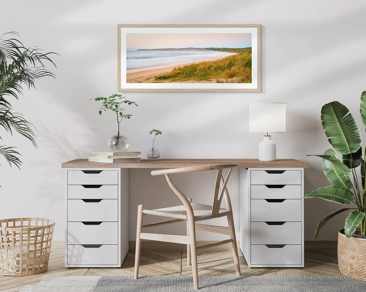 Seaside Dawn. Wall art print of a sunrise at Durras Beach, with a timber frame, hung above a home office desk. 