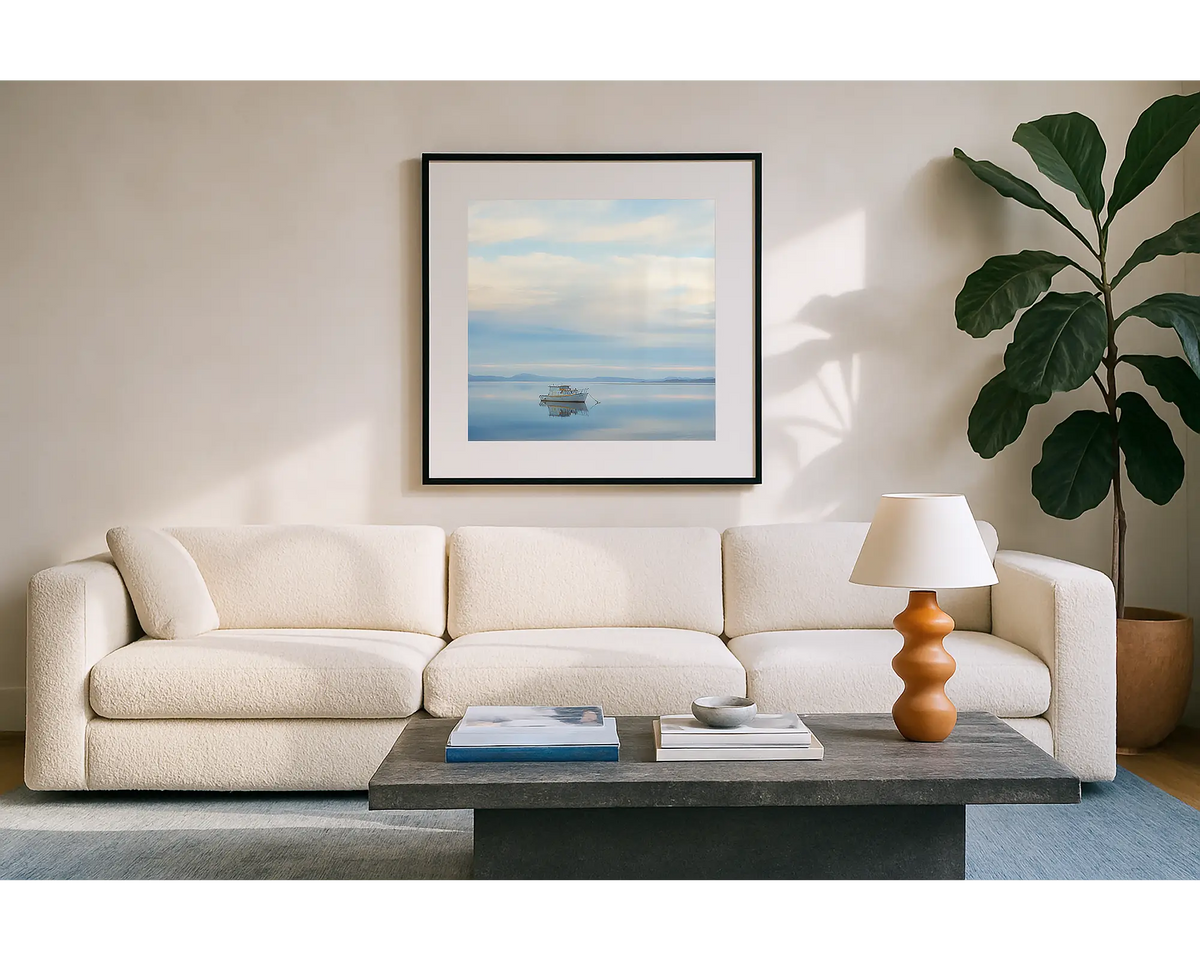 Serenity. Wall art print of a boat on Macquarie Harbour, Tasmania, with a black frame hung in a sunlit lounge room. 