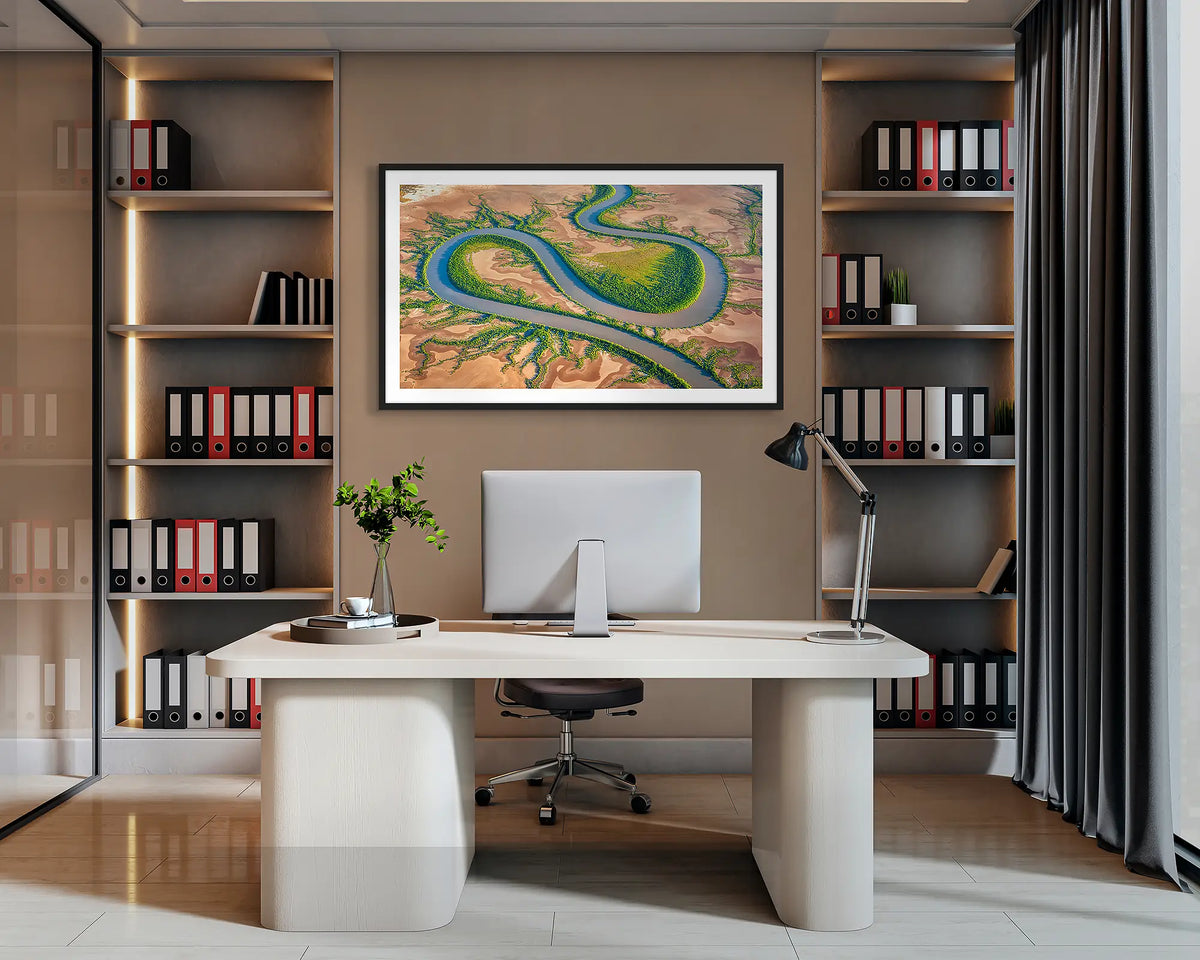 Serpent. Wall art print of King River, the Kimberley, with a black frame, hanging behind a desk in a corporate office. 