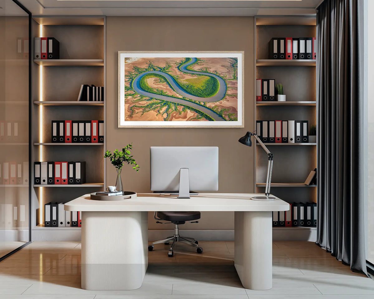 Serpent. Wall art print of King River, the Kimberley, with a Tasmanian Oak frame, hanging behind a desk in a corporate office. 