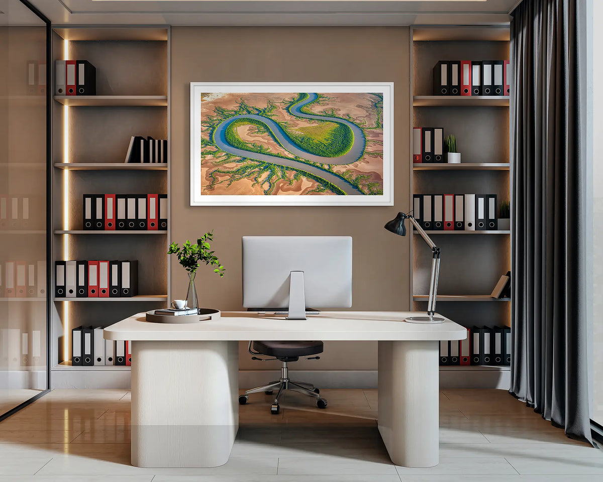 Serpent. Wall art print of King River, the Kimberley, with a white frame, hanging behind a desk in a corporate office. 