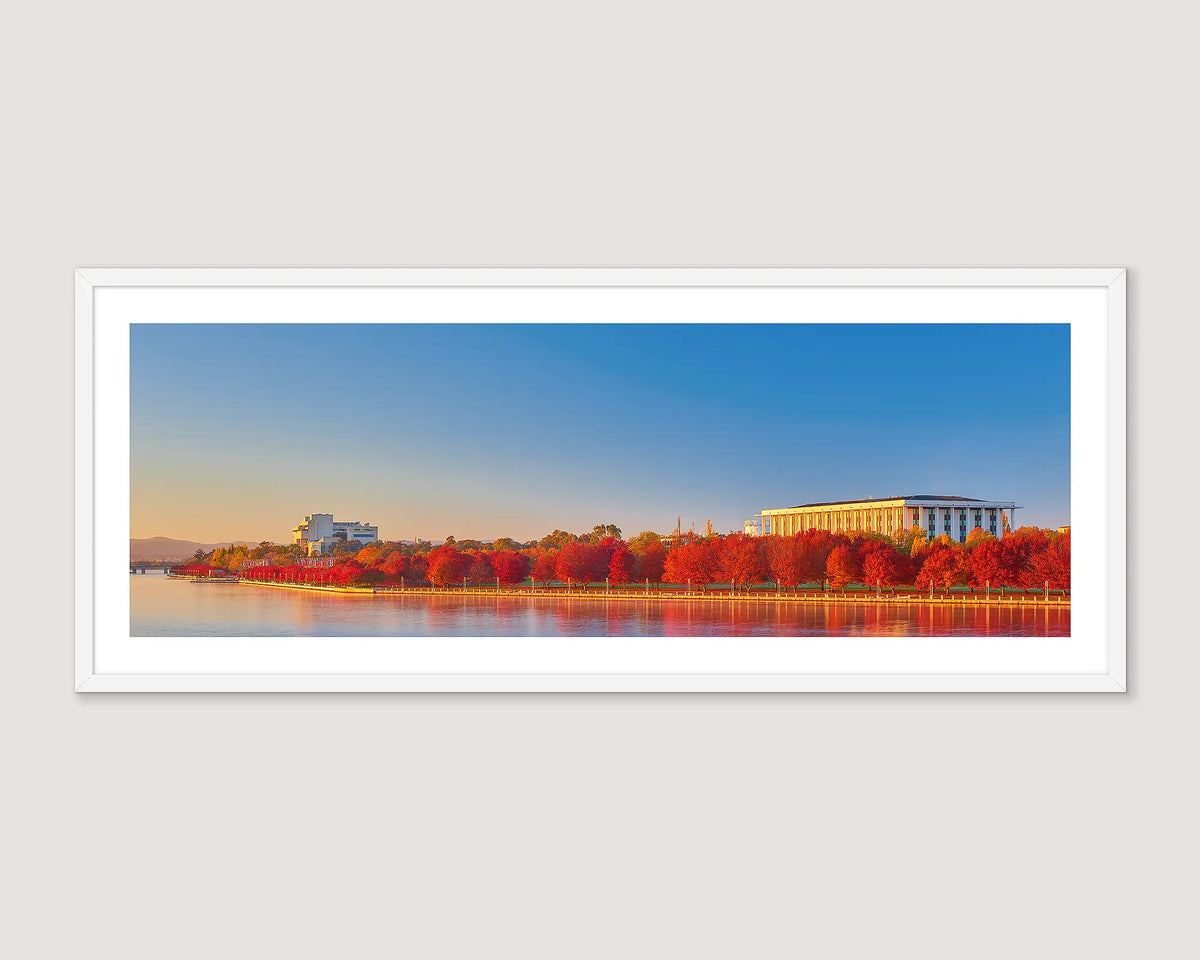 Framed panoramic view of a The National Library and High Court of Australia with autumn trees and water reflection.