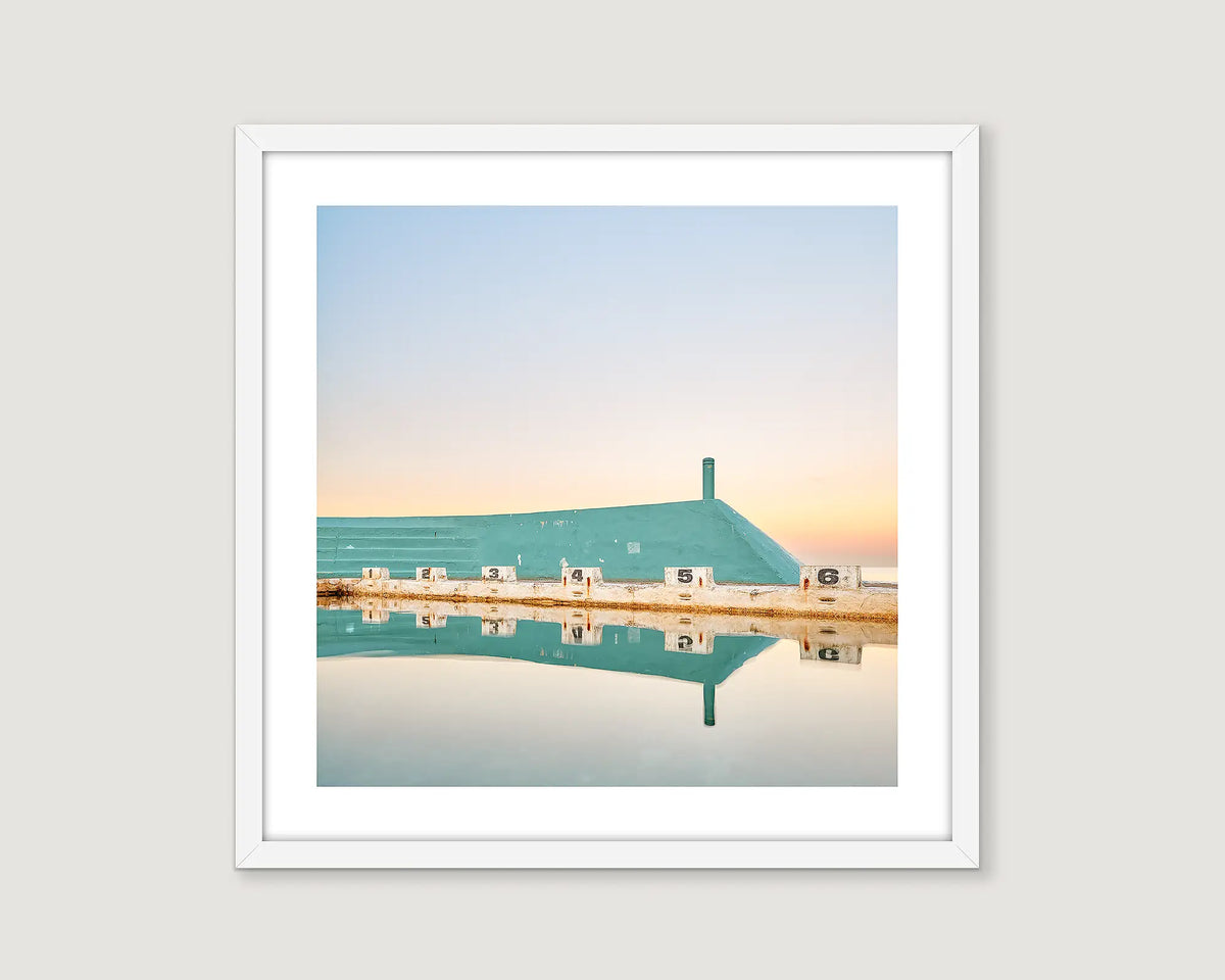 Framed artwork of Newcastle Ocean Baths with diving blocks reflected in the water.