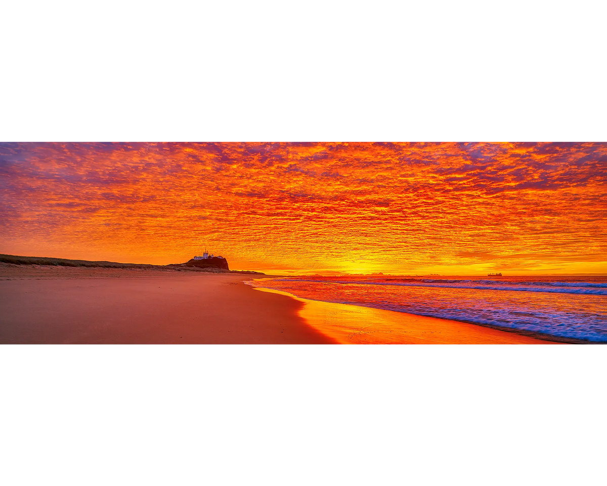 Sky Fire. Sunrise lighting the sky over Nobby&#39;s Beach, Newcastle, New South Wales, Australia.