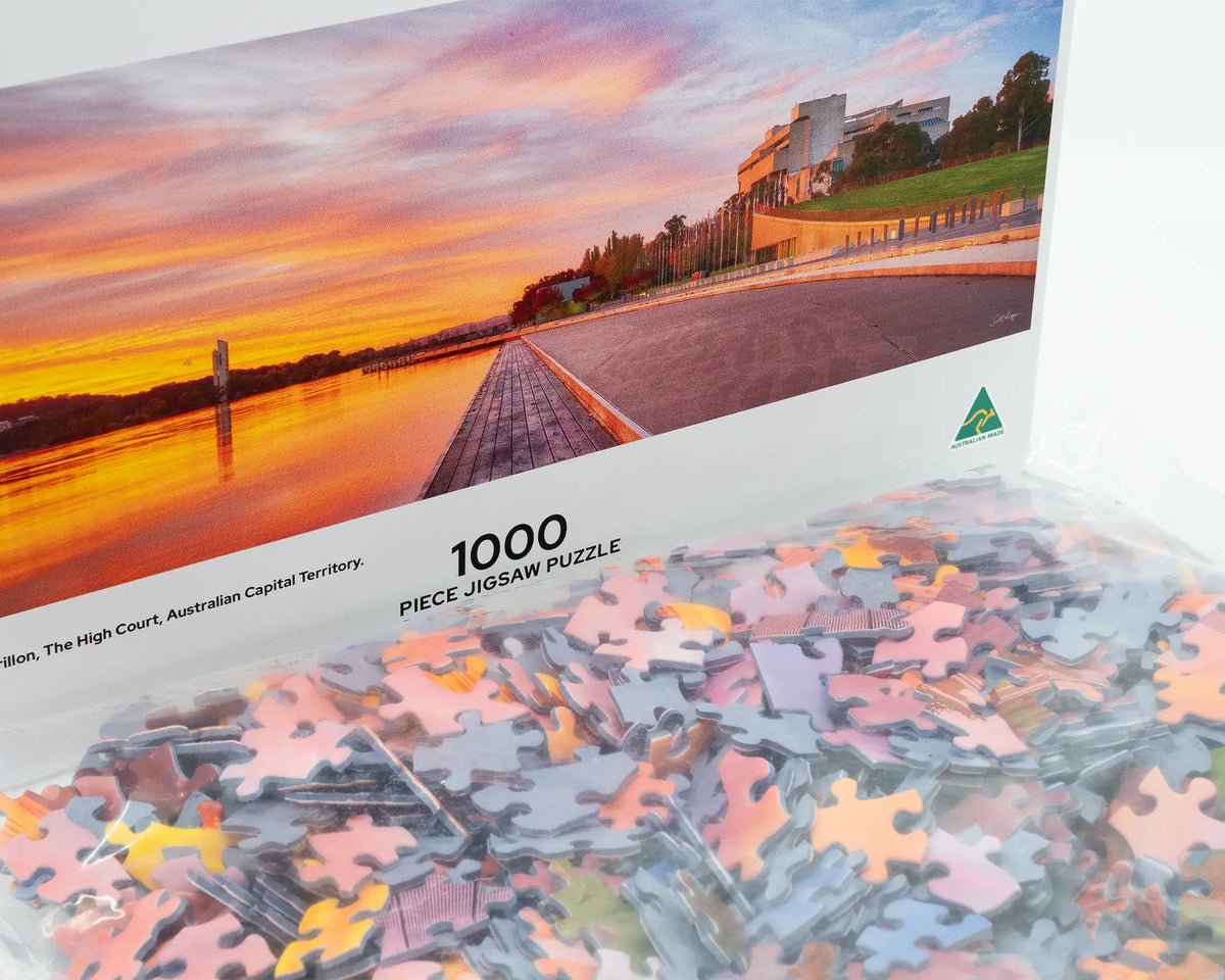 Sky Light. 1000 piece jigsaw puzzle open box showing puzzle pieces of sunrise over Lake Burley Griffin, Canberra.