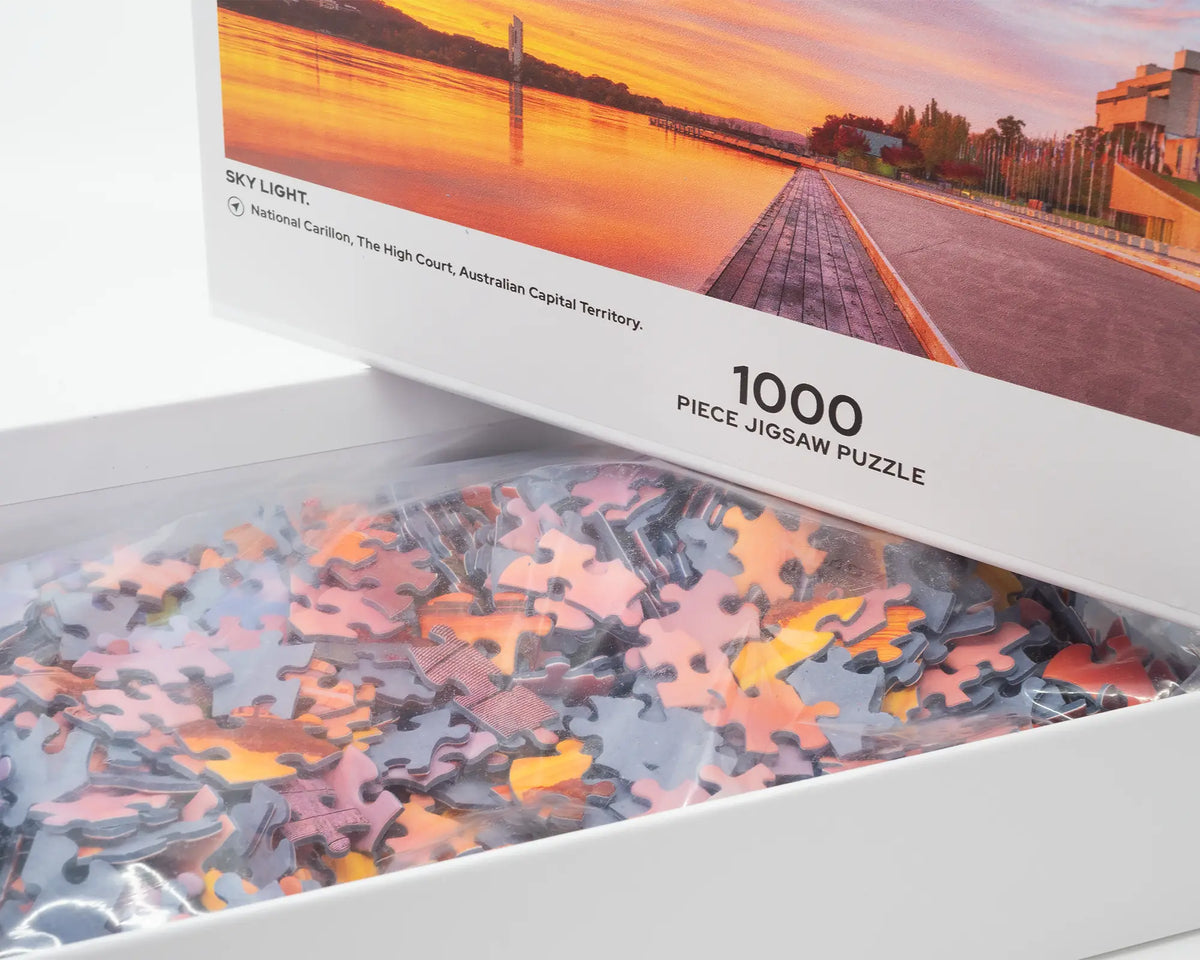 Sky Light. 1000 piece jigsaw puzzle sunrise over Lake Burley Griffin, Canberra, open box showing puzzle pieces.