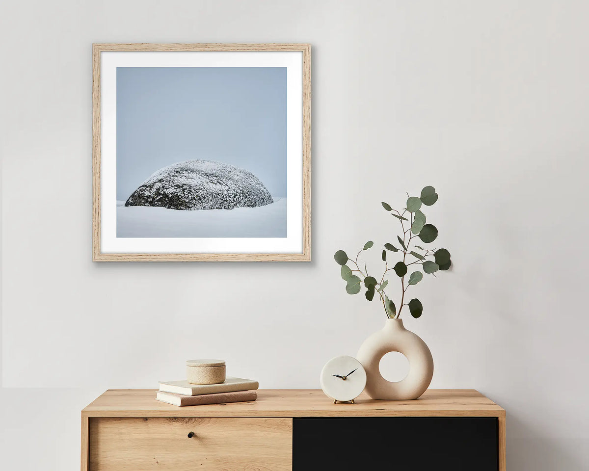 Snow Dome. Framed wall art print of a rock covered in ice with a timber frame, hung above a small entrance table.