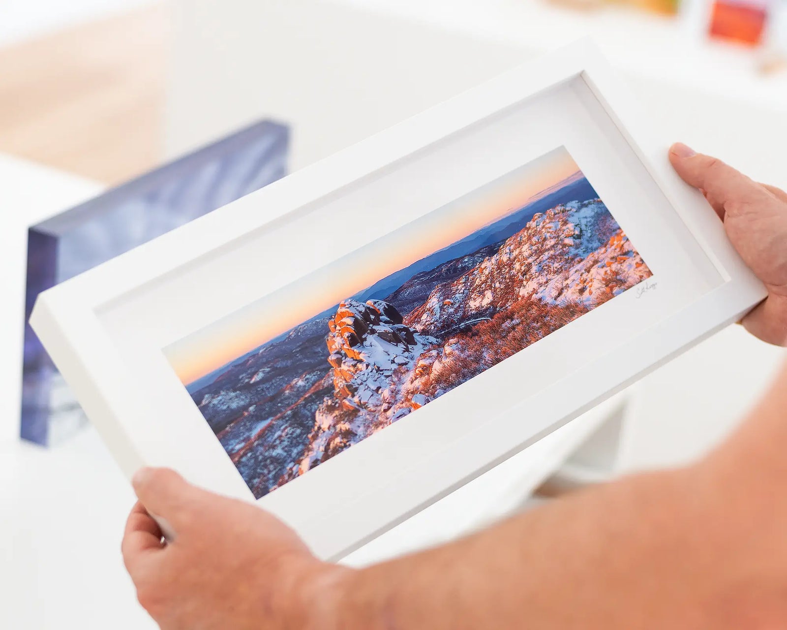 Framed panoramic landscape of a snowy Cathedral mountain peak with a sunset sky.