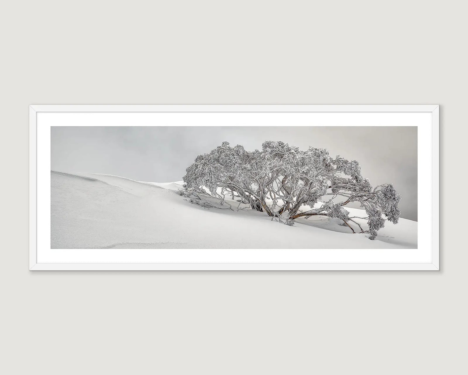 Framed artwork of a tree in a snowy landscape.