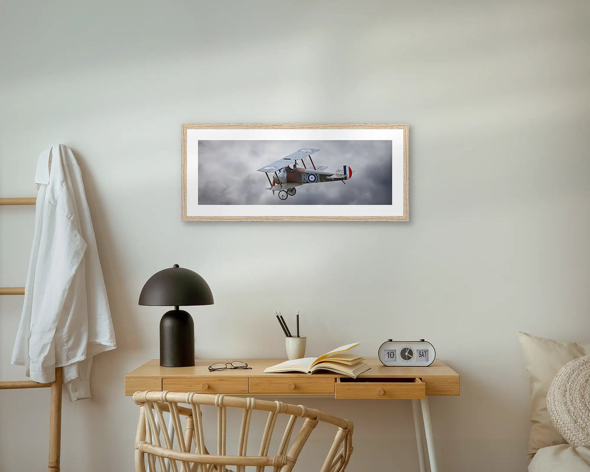 Sopwith Camel. Aviation wall art print, with a timber frame, above a small desk.