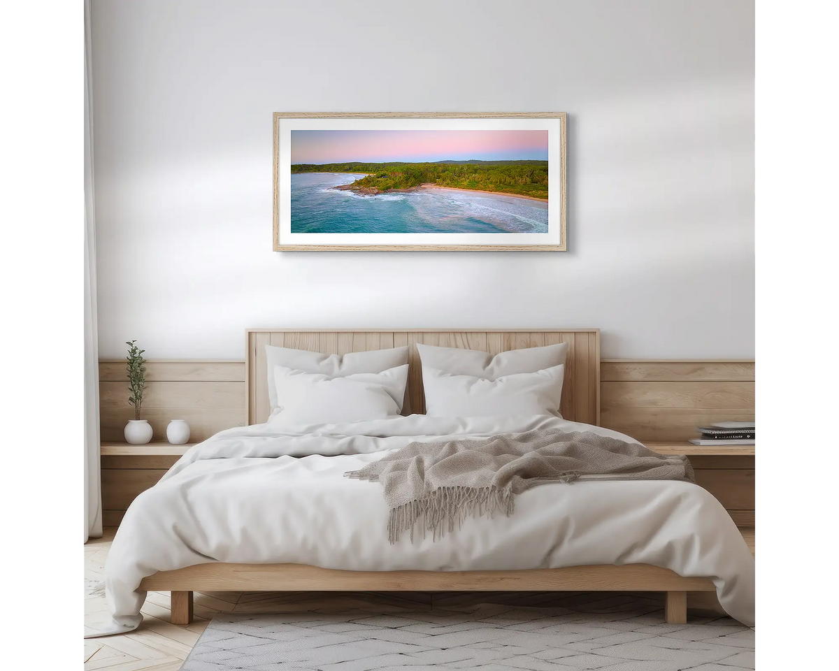 South Coast Escape. Wall art print of a sunrise over Durras, with a timber frame hung above a bed. 