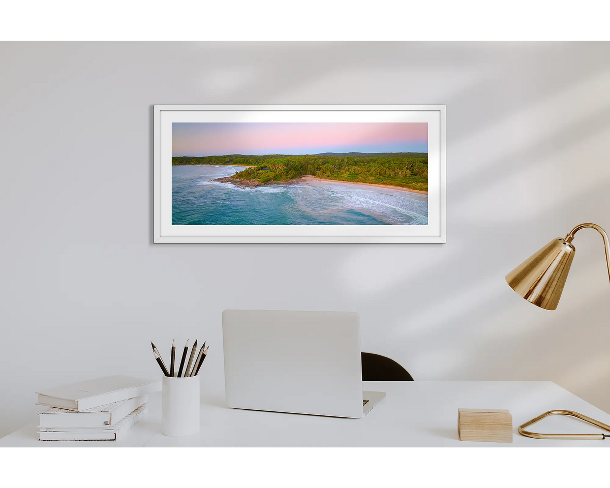 South Coast Escape. Wall art print of a sunrise over Durras, with a white frame in a work from home office. 