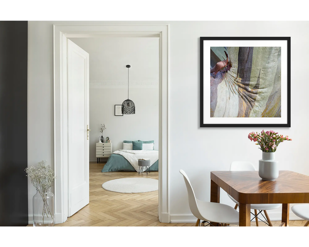 Squish. Abstract wall art print of snow gum bark on Mount Buller, framed with a black fame and hung near a wooden dining table. 