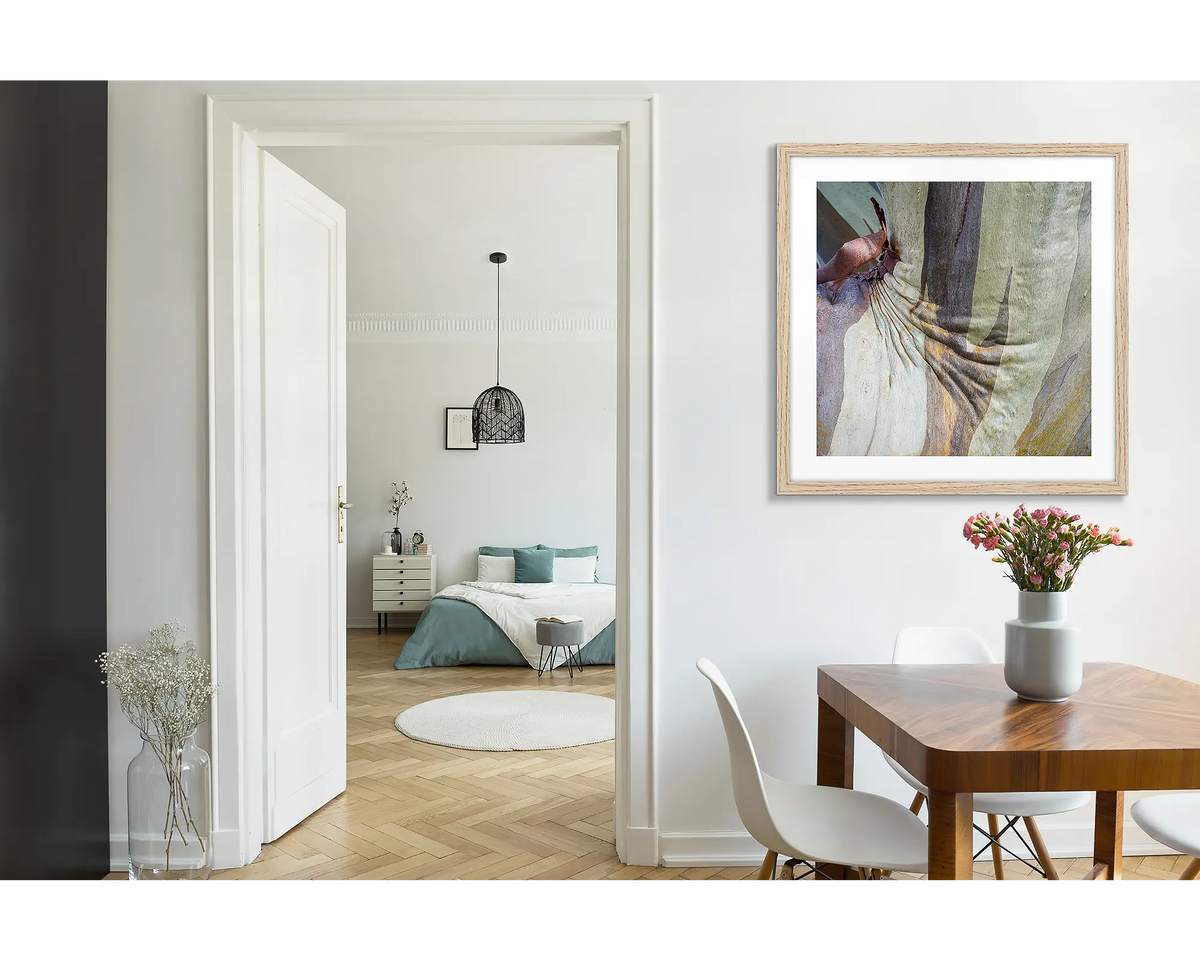 Squish. Abstract wall art print of snow gum bark on Mount Buller, framed with a timber fame and hung near a wooden dining table. 