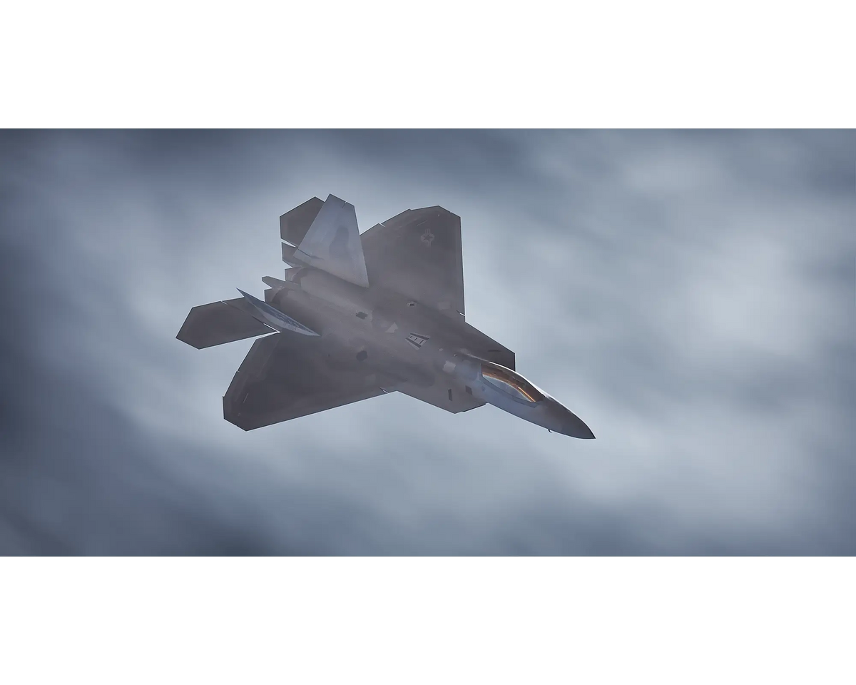 Stealth Fighter. United STates Air Force F-22 Raptor flying next to clouds.