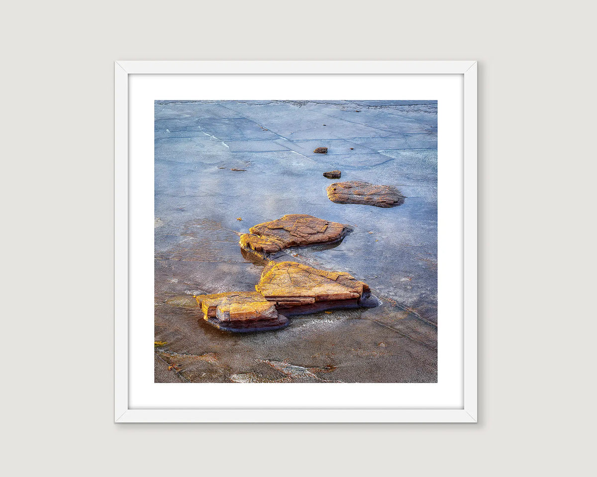 Framed abstract photograph of rocks in water.
