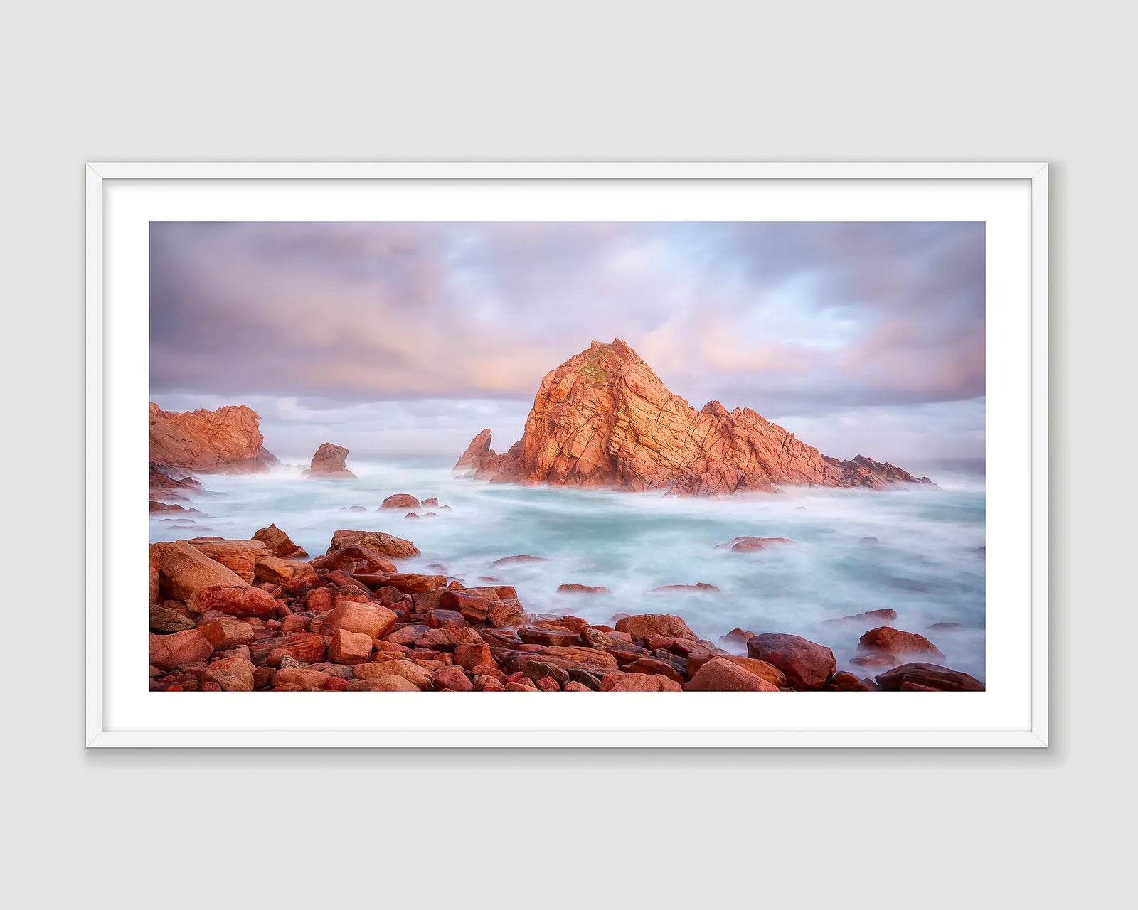 Framed photograph of a rock formation in a stormy sea.