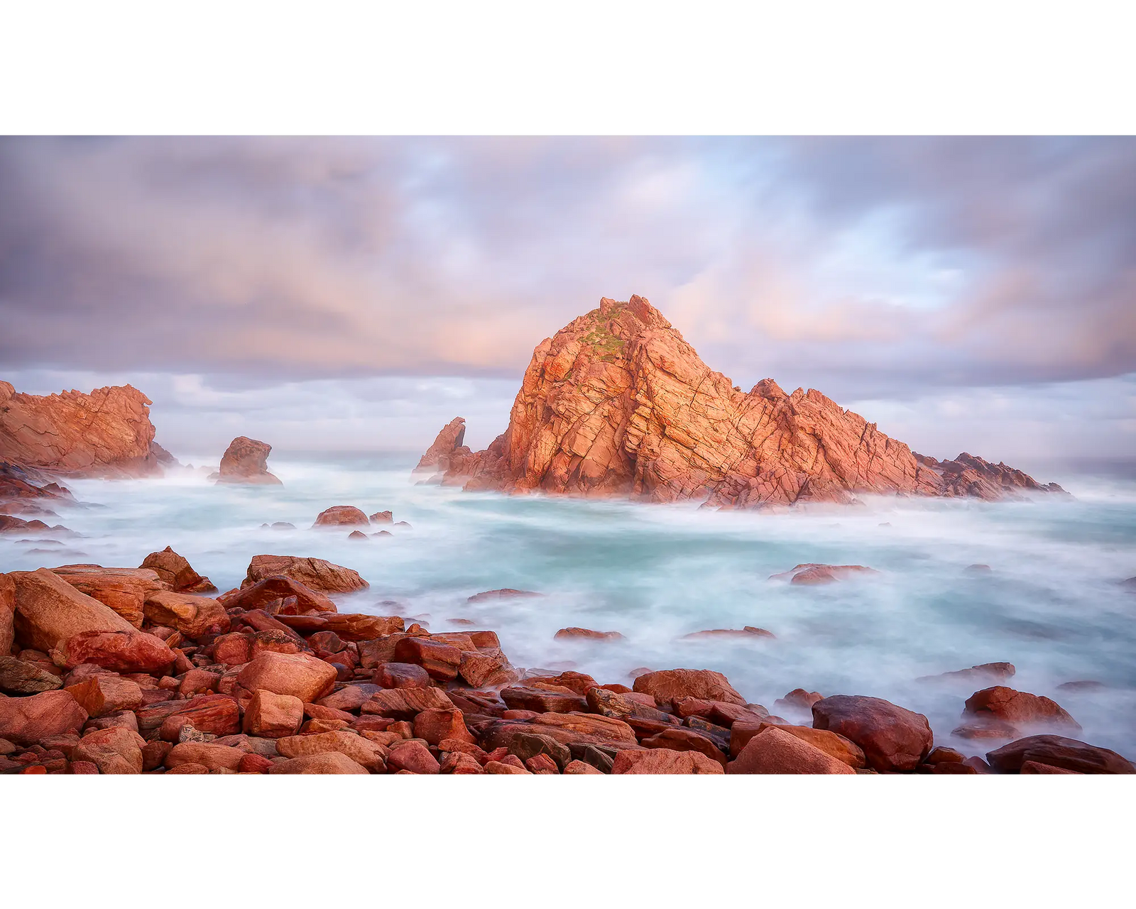 Framed photograph of a rock formation in a stormy sea.