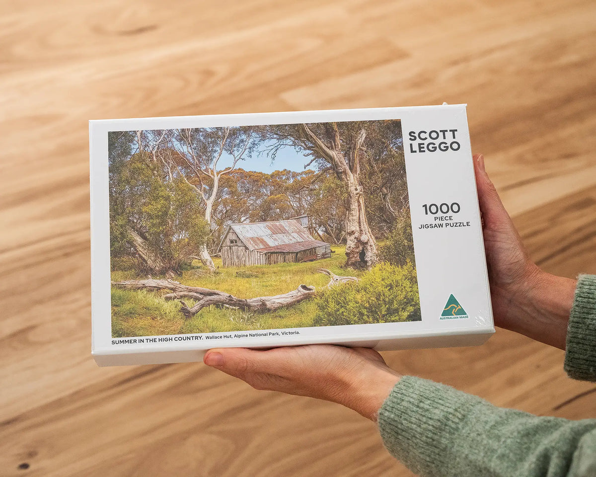 Summer In The High Country 1000 piece Wallace Hut jigsaw puzzle being held.