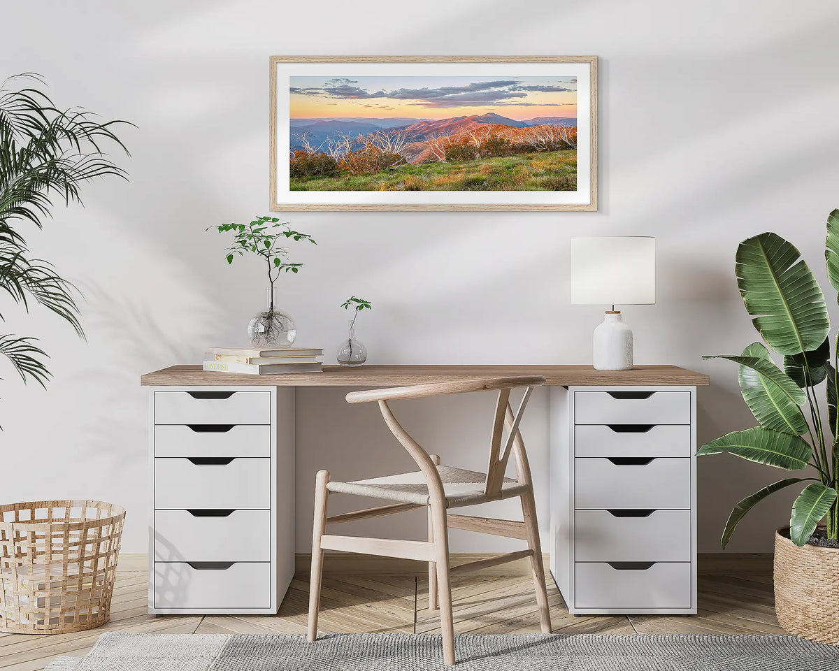 Summer Razorback. Framed wall art print of a sunset over the razorback and Mount Feathertop, framed in a Tassie Oak frame and hung above a desk. 