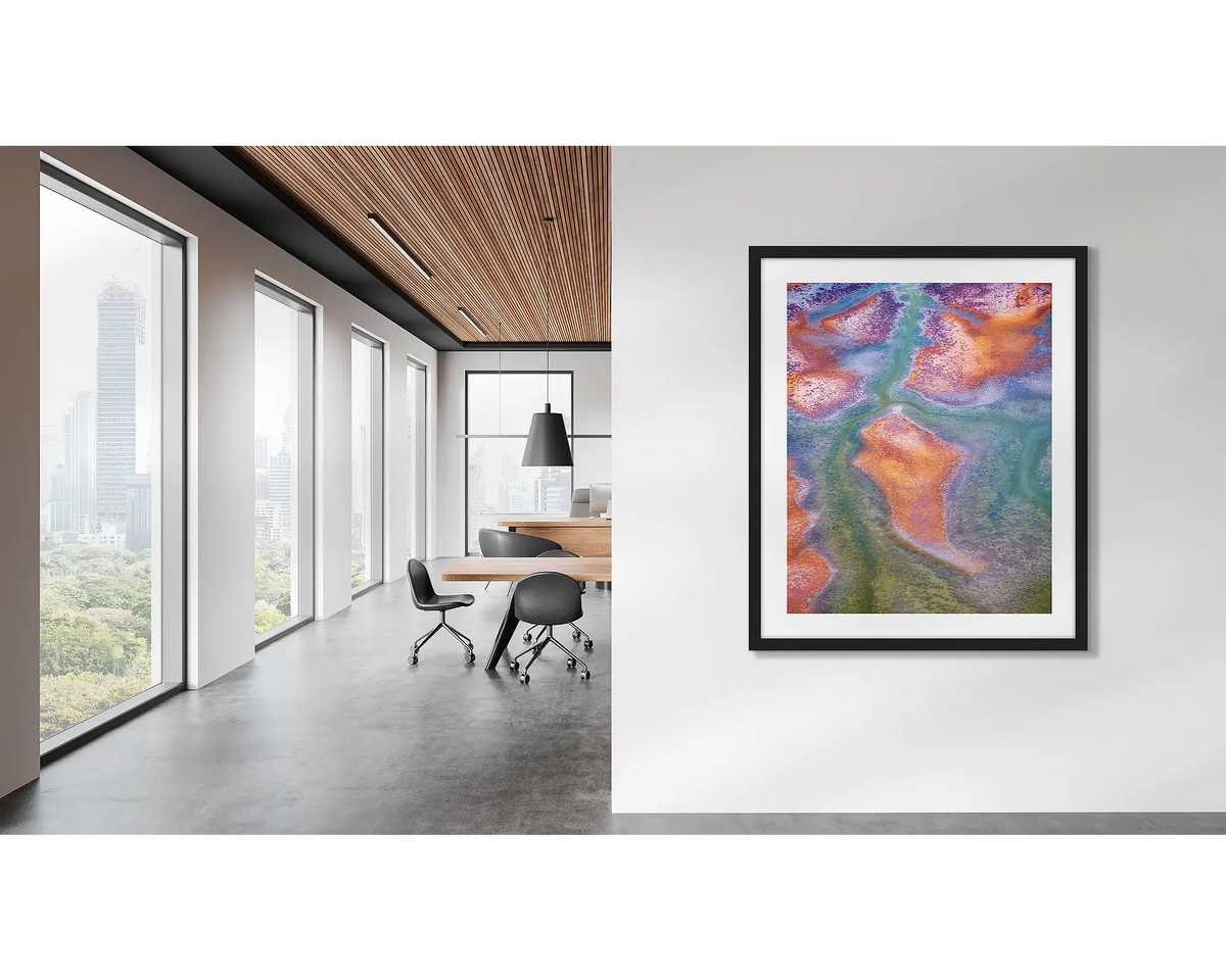 Surface. Framed Kimberley, abstract artwork framed in a black frame, hanging in a modern office. 