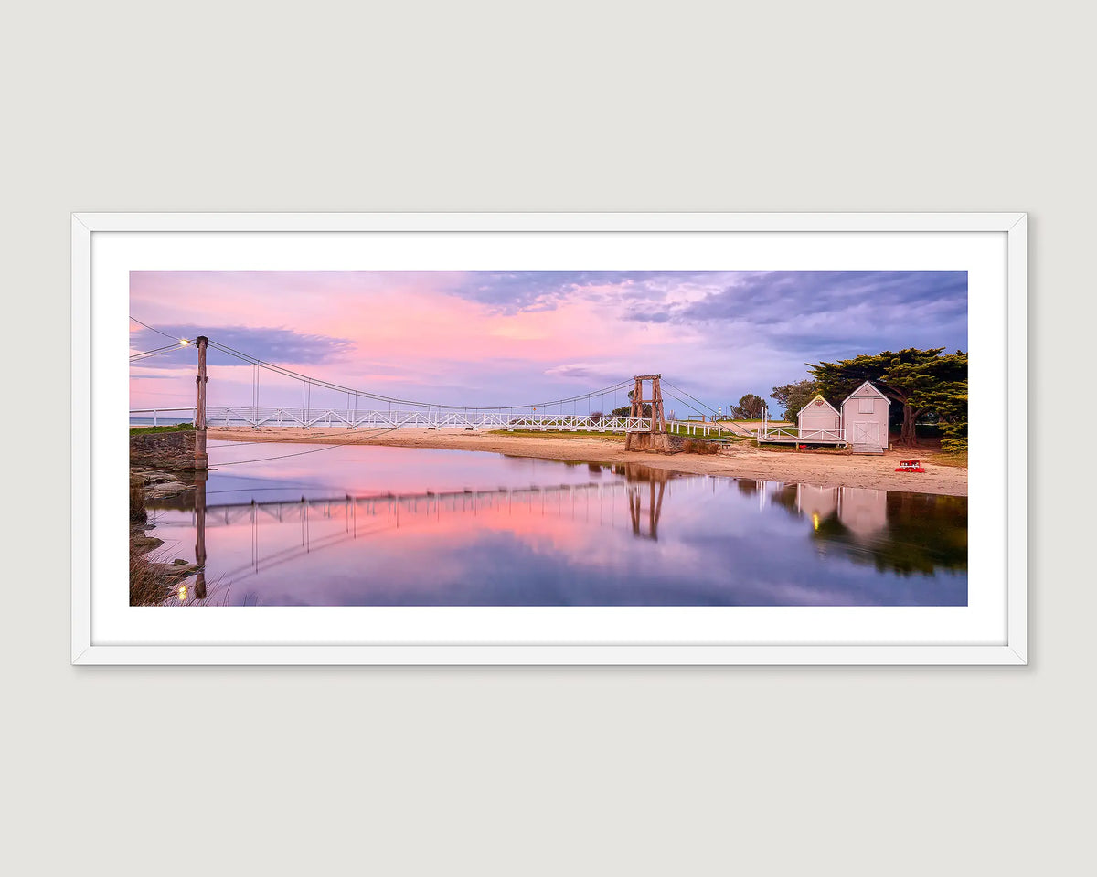 Framed photograph of a suspension bridge with a pink and blue sky reflection in water at Lorne Victoria.