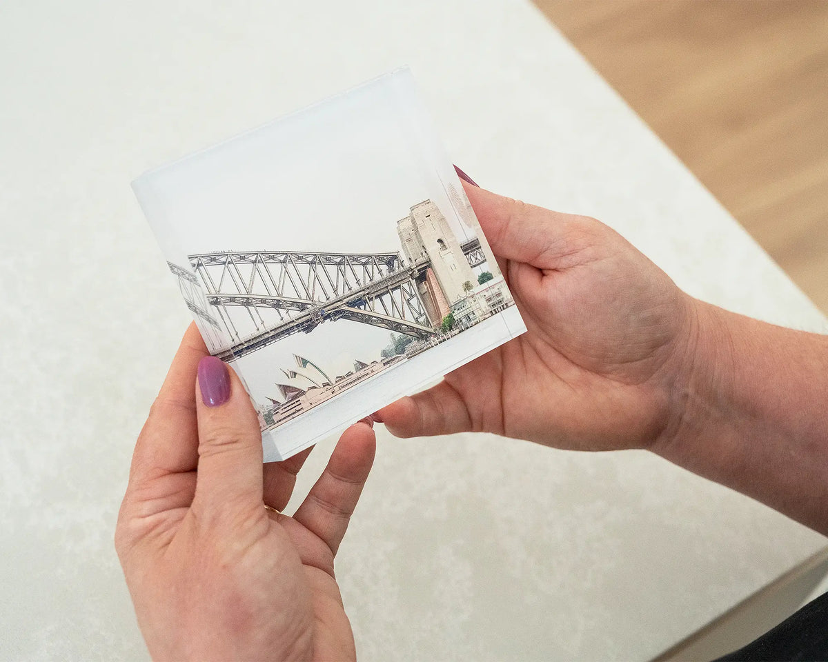 Sydney Icons. Acrylic block of the Opera House and Sydney Harbour Bridge, being held in hands.