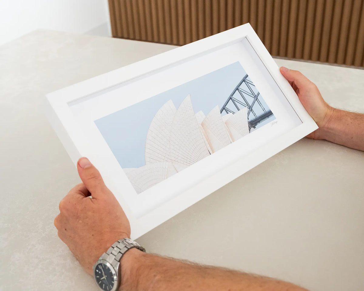 Sydney Outlines. Small framed print featuring the Opera House and Harbour Bridge, Sydney, held in hands.