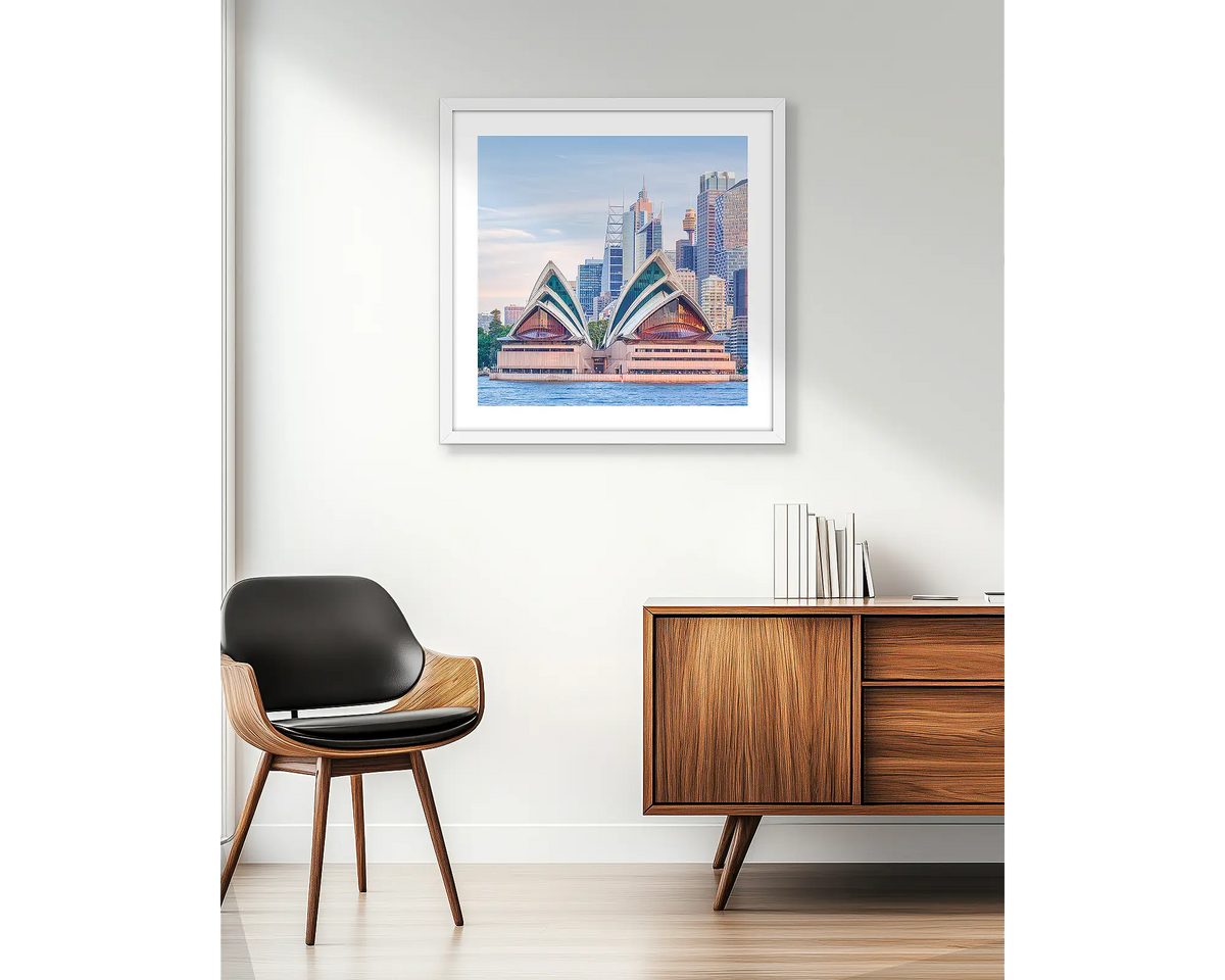 Sydney Views. Wall art print of Sydney Opera House and C.B.D buildings, framed in a white frame and hung beside an apartment window. 