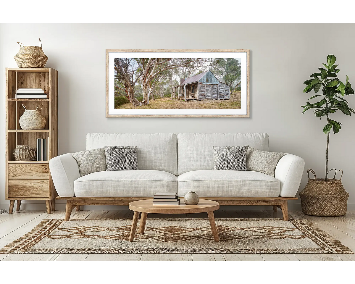 Tales of the Stockman. Wall art print of Wheelers Hut in Kosciuszko National Park with a timber frame hung above a couch.
