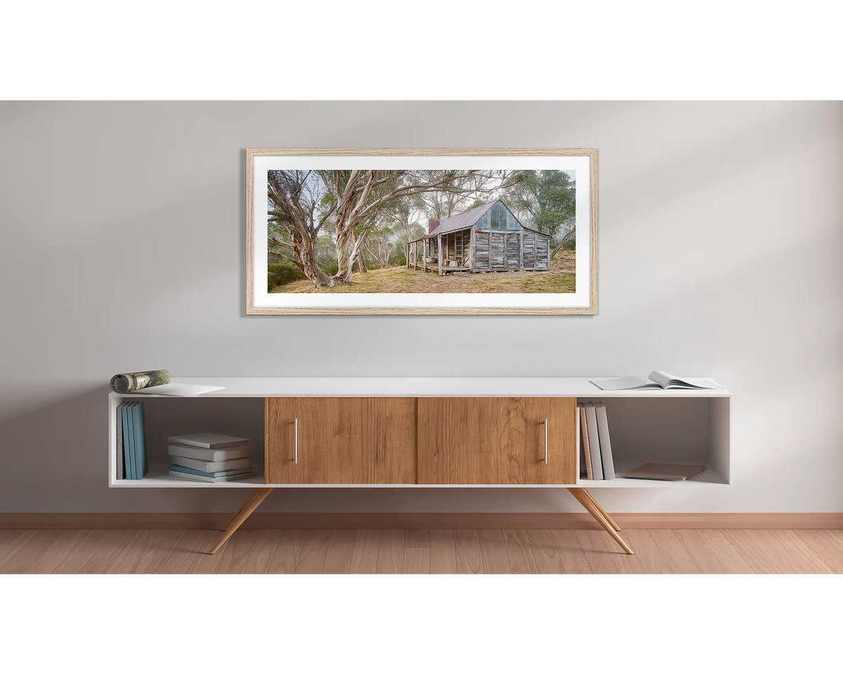 Tales of the Stockman. Wall art print of Wheelers Hut in Kosciuszko National Park with a timber frame hung above a side table.