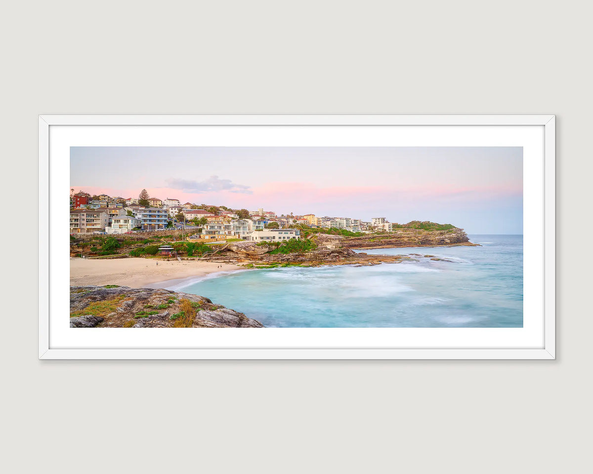 Framed artwork of a coastal scene with houses and a beach at Tamarama.