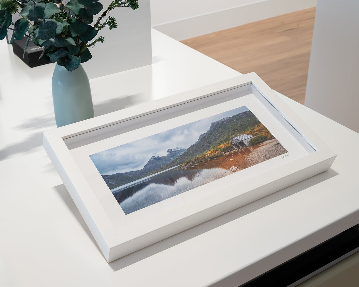 Tassie Icons. Cradle Mountain Dove Lake boat shed with white frame, on display in gallery.