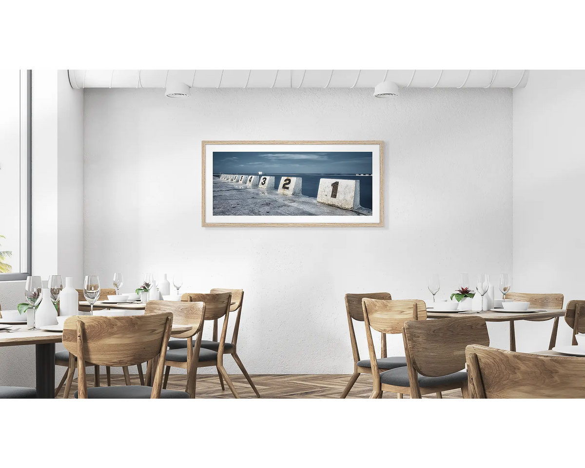 Ten. Merewether ocean baths wall art in a  timber frame hung in a cafe. 