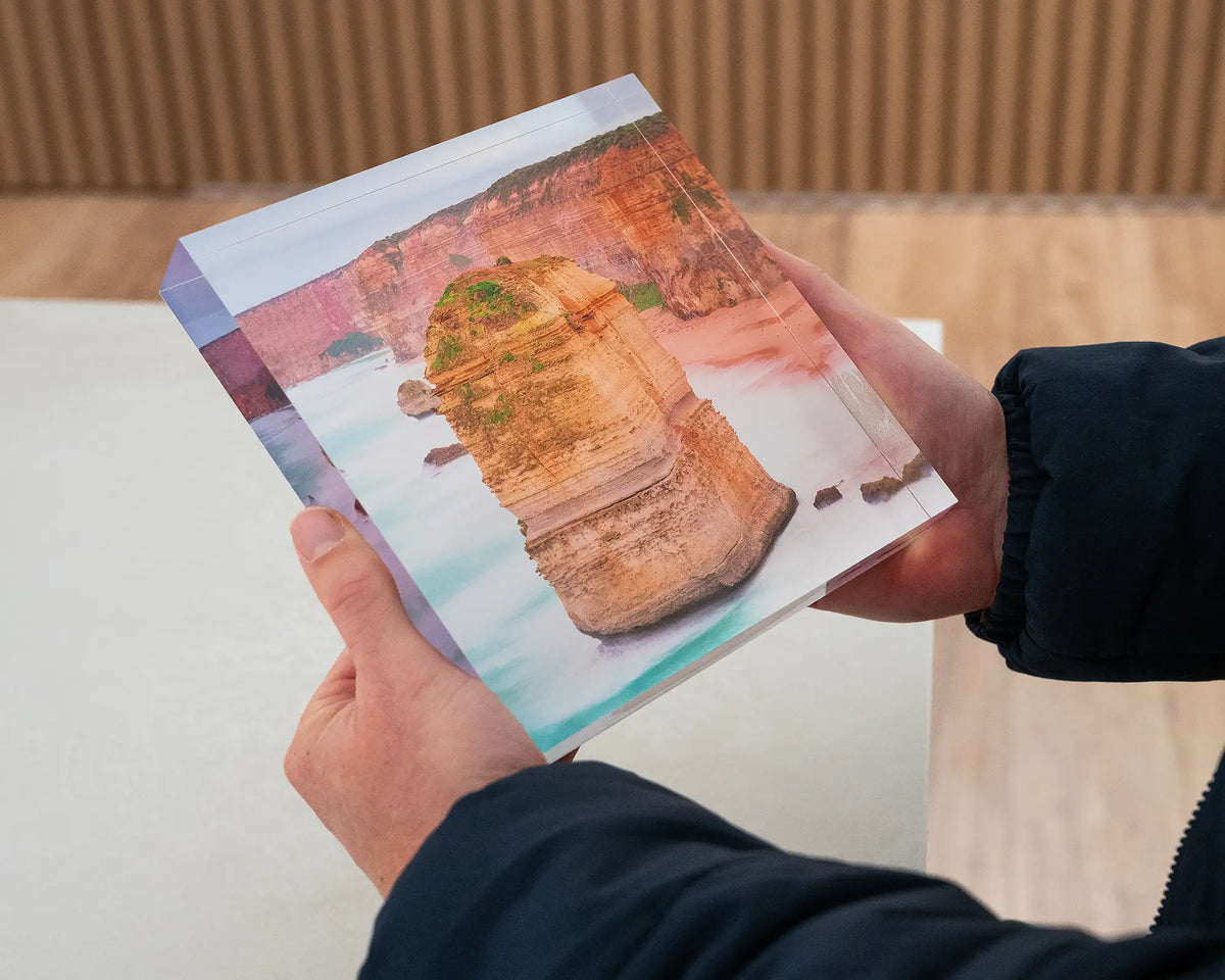 The Apostle. Acrylic block Twelve Apostles, Great Ocean Road, Victoria, held in hands.