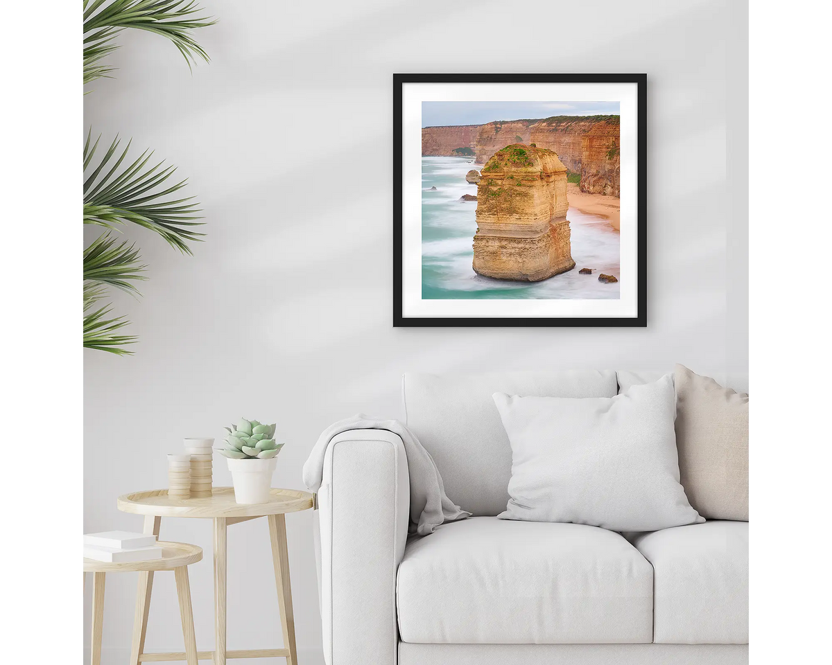 The Apostle. Great Ocean Road wall art print with a black frame hung above a couch. 