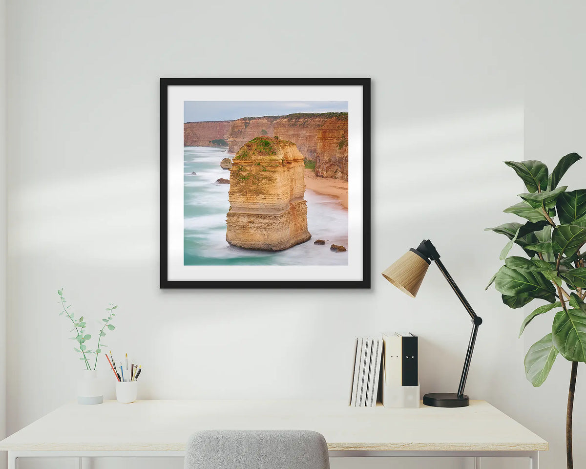 The Apostle. Great Ocean Road wall art print with a black frame hung above a small home office desk. 
