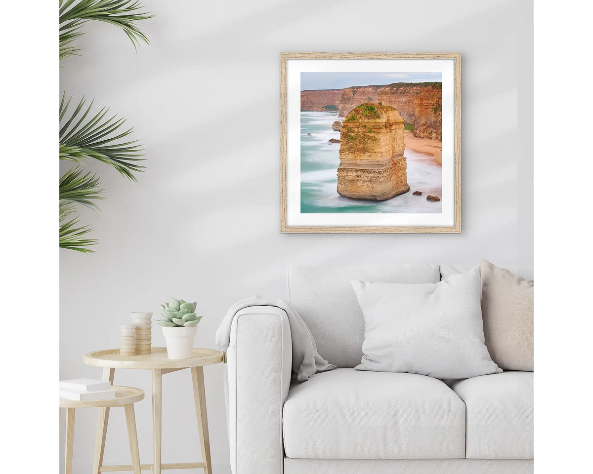 The Apostle. Great Ocean Road wall art print with a timber frame hung above a couch. 