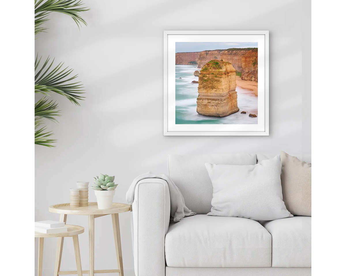 The Apostle. Great Ocean Road wall art print with a white frame hung above a couch. 